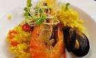 Paella z ryżem smażonym na cebuli, z kawałkami kurczaka, krewetką królewską, mulami, sowicie doprawiona papryką, kolendrą i skropiona - opalaną – cytryną 